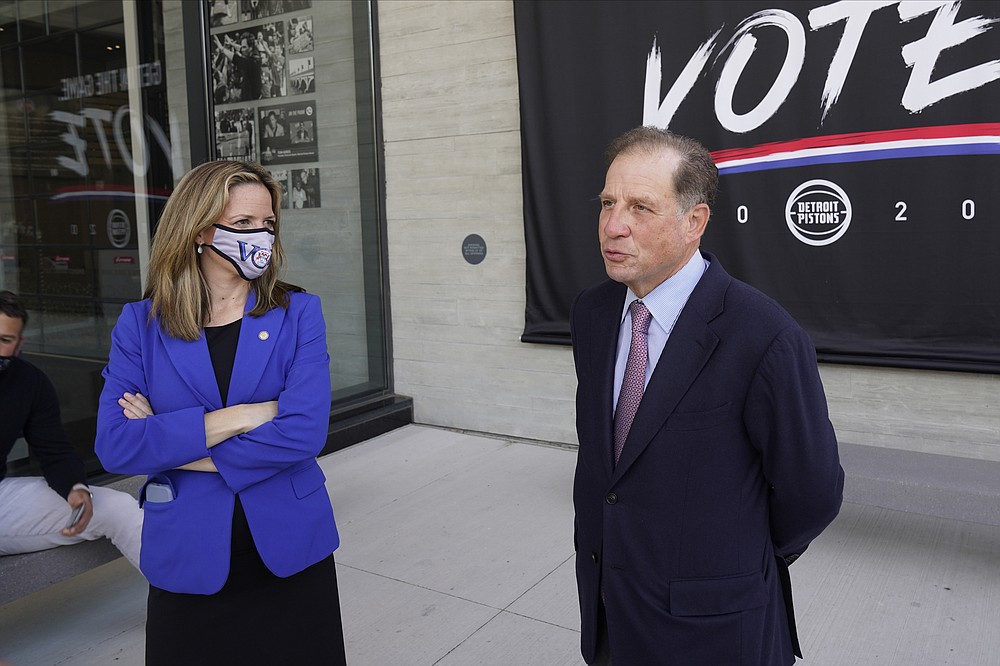 FILE - In this Sept. 24, 2020, file photo, Michigan Secretary of State Jocelyn Benson and Detroit Pistons Vice Chairman Arn Tellem talk about voting and the upcoming elections in Detroit. NFL, NBA, NHL, Major League Baseball, Major League Soccer and college venues are serving various roles in unprecedented ways, including providing space for people to vote while social distancing on Election Day. The Henry Ford Detroit Pistons Performance Center and Ford Field, where the Lions play, will provide socially distant space for receiving boards to double check ballots after they are counted at precincts in the Motor City. (AP Photo/Paul Sancya, File)