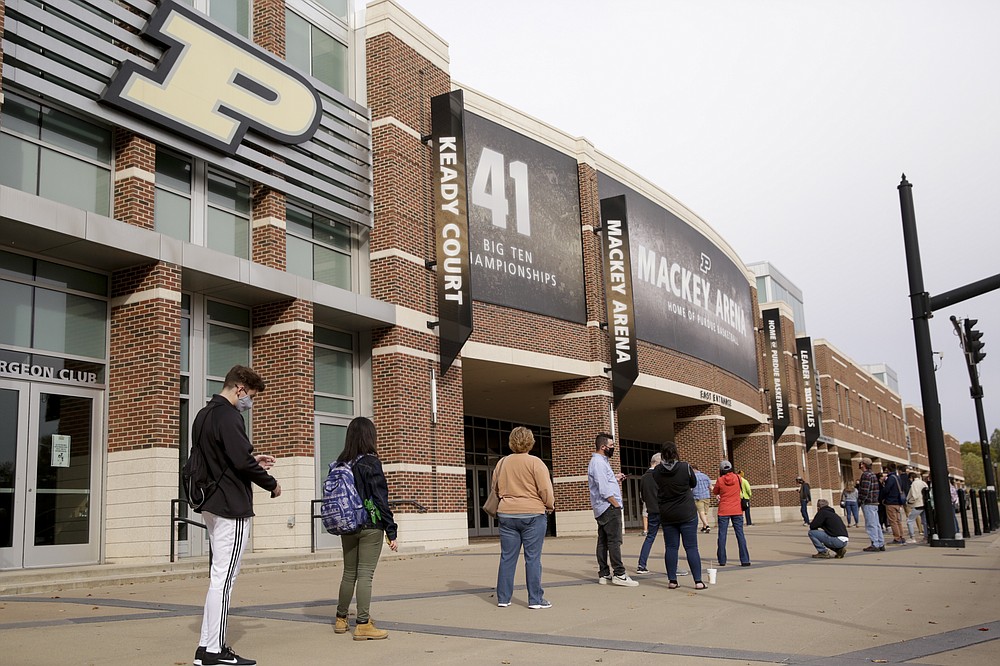 FILE - In this Oct. 14,l 2020, file photo, voters line up outside Purdue University's Mackey Arena for early voting ahead of the 2020 general election, in West Lafayette, Ind. The Tippecanoe County Board of Elections used Mackey Arena as a satellite polling location Wednesday. NFL, NBA, NHL, Major League Baseball, Major League Soccer and college venues are serving various roles in unprecedented ways, including providing space for people to vote while social distancing on Election Day. (Nikos Frazier/Journal & Courier via AP)