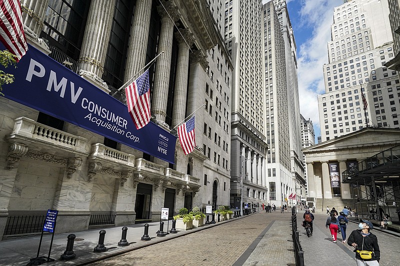 FILE - Pedestrians pass the New York Stock Exchange, Friday, Oct. 2, 2020, in New York.   U.S. stocks are drifting on Thursday, Oct. 22,  as more big companies report profits for the summer that were better than Wall Street feared.  (AP Photo/John Minchillo)