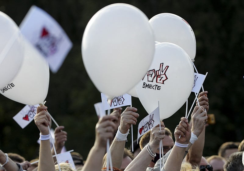 FILE - In this Thursday, July 30, 2020 file photo, people wave white balloons with the words "Together" as they attend a meeting in support of Sviatlana Tsikhanouskaya in Minsk, Belarus. The European Union has awarded its top human rights prize to the Belarus opposition movement and its leader Sviatlana Tsikhanouskaya for their challenge to President Alexander Lukashenko's long hard-line reign. (AP Photo/Sergei Grits, File)