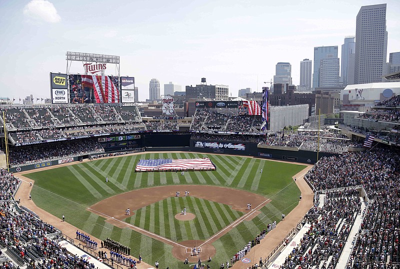 FILE - In this June 30, 2013, file photo, members of the Armed Forces hold a large flag at Target field in Minneapolis where the Minnesota Twins hosted Armed Forces Appreciation Day prior to the baseball game between the Twins and the Kansas City Royals. The NHL has canceled the 2021 Winter Classic and All-Star Weekend. The Winter Classic was scheduled to be played New Year's Day outdoors at Target Field in Minneapolis between the Minnesota Wild and St. Louis Blues. The Florida Panthers were set to host All-Star festivities in Sunrise in late January. (AP Photo/Jim Mone, File)