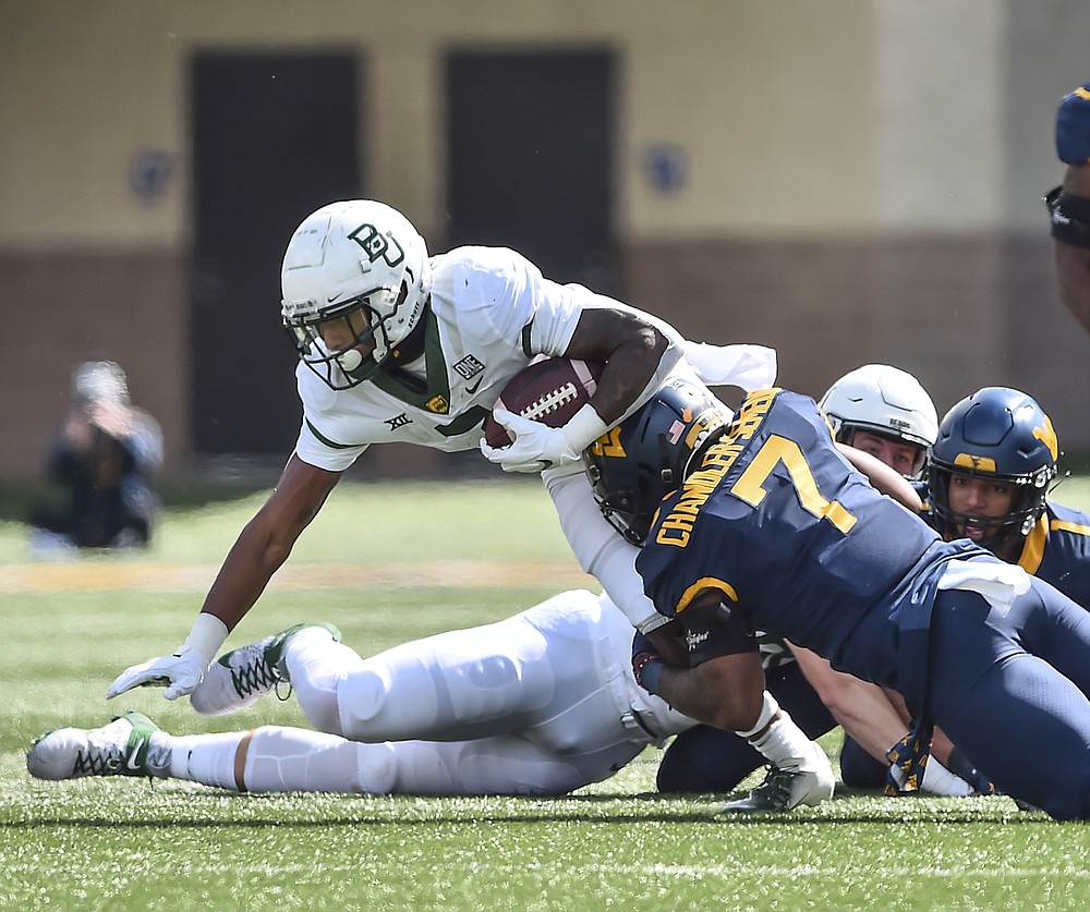 Baylor running back John Lovett (7) is tackled by West Virginia linebacker Josh Chandler-Semedo (7) during an NCAA college football game, Saturday, Oct. 3, 2020, in Morgantown, W.Va. (William Wotring/The Dominion-Post via AP)