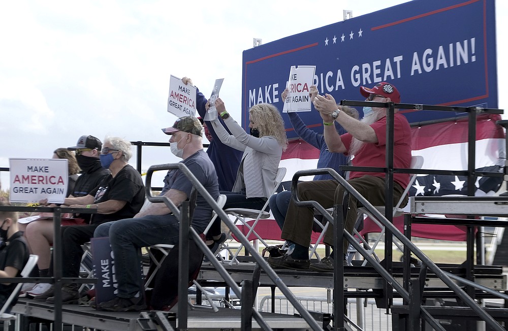 Supporters of Vice President Mike Pence hold up signs during his rally at the Grand Aire hanger of the Eugene F. Kranz Toledo Express Airport in Swanton, Ohio on Friday, Oct. 23, 2020. (Lori King/The Blade via AP)