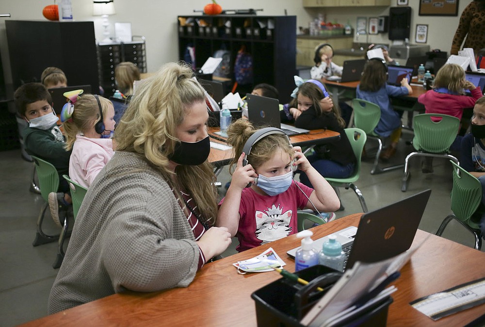 Kim Crawford, kindergarten teacher, (from left) helps Emilea May with an assignment, Monday, October 5, 2020 at Clinton Elementary School in Clinton. Check out nwaonline.com/2010010Daily/ for today's photo gallery. (NWA Democrat-Gazette/Charlie Kaijo)