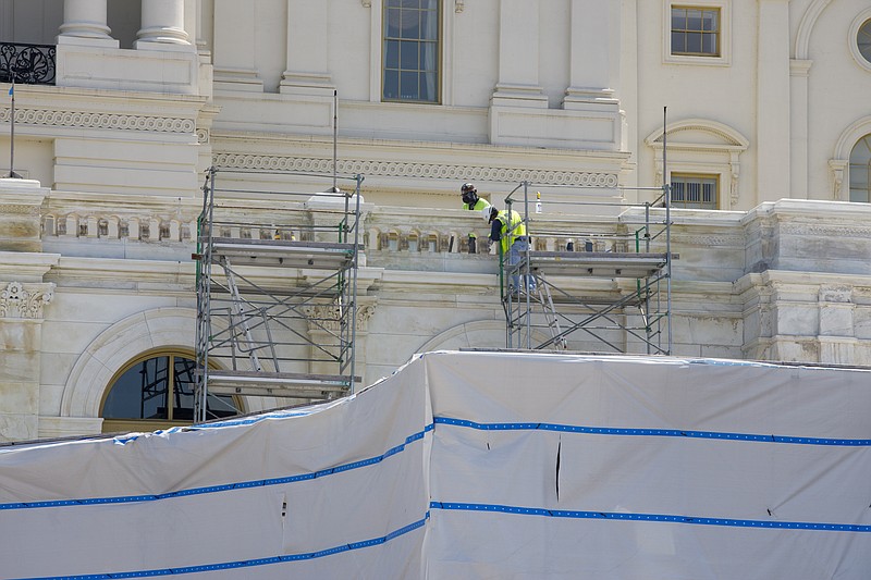 Workers on the West Front of the U.S. Capitol on Aug. 7 in Washington. While much of Washington is twisted in knots over the upcoming election, there’s another contingent already busy trying to figure out how to stage an inauguration for the next president during a pandemic. - AP Photo/Jon Elswick