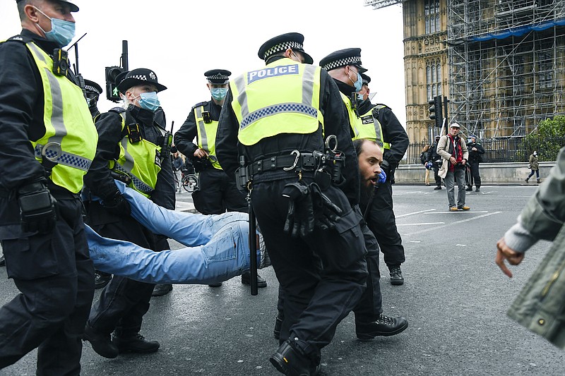 Police detain a man, during a coronavirus anti-lockdown protest on Westminster Bridge, in London, Saturday. - AP Photo/Alberto Pezzali