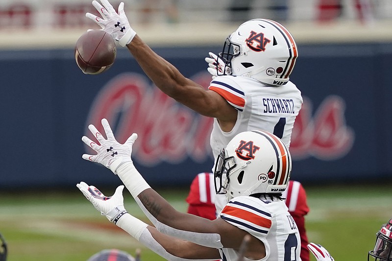 Auburn wide receivers Anthony Schwartz (1) and Ze'Vian Capers (80) both reach for an errant pass during the first half of an NCAA college football game against Mississippi in Oxford, Miss., Saturday, Oct. 24, 2020. (AP Photo/Rogelio V. Solis)