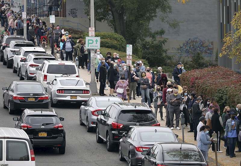 Voters line up in front of the Yonkers Public Library in Yonkers, N.Y., on Saturday as the first day of early voting in the presidential election begins across New York state. - Mark Vergari/The Journal News via AP