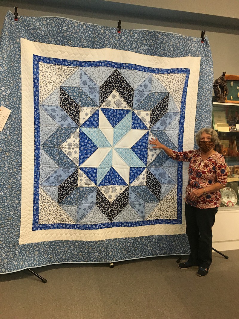 Brenda Doucey, a Progressive Women’s Association member, shows off the handmade quilt that is being raffled off to raise money for the group's Ann Douthit Memorial Scholarship fund. It was made by Mary Ann Davis. (Special to The Commercial/Deborah Horn )