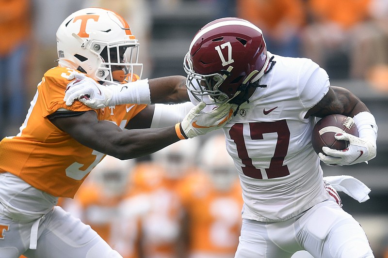 Alabama wide receiver Jaylen Waddle (17) pushes away Tennessee defensive back Kenney Solomon (31) during an NCAA college football game in Knoxville, Tenn., Saturday, Oct. 24, 2020. (Caitie McMekin/Knoxville News Sentinel via AP)