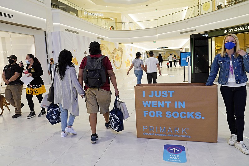 FILE - In this Thursday, Oct. 1, 2020, file photo, shoppers and pedestrians walk through a concourse at the American Dream Mall in East Rutherford, N.J. U.S. consumer confidence dipped slightly in October as a new wave of coronavirus cases began across the country. The Conference Board reported Tuesday, Oct. 27, 2020,  that its consumer confidence index fell to a reading of 100.9, from 101.8 in September. (AP Photo/Kathy Willens, File)