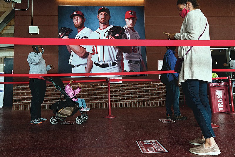 Early voting begins in the District of Columbia as voters wait in line at an early voting center at Nationals Park, Tuesday, Oct. 27, 2020, in Washington. (AP Photo/Jacquelyn Martin)