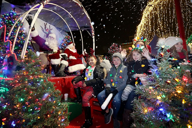 NWA Arkansas Democrat-Gazette/DAVID GOTTSCHALK  Mr. and Mrs. Santa Claus arrive on a float Friday, November 22, 2019 during the parade on the first night of the annual Lights of the Ozarks event in downtown Fayetteville. The lights illuminate the square each evening from 5:00 p.m. to 1:00 a.m. The city of Fayetteville Parks and Recreation department uses more than 400,000 lights. The lights remain on through December 31.