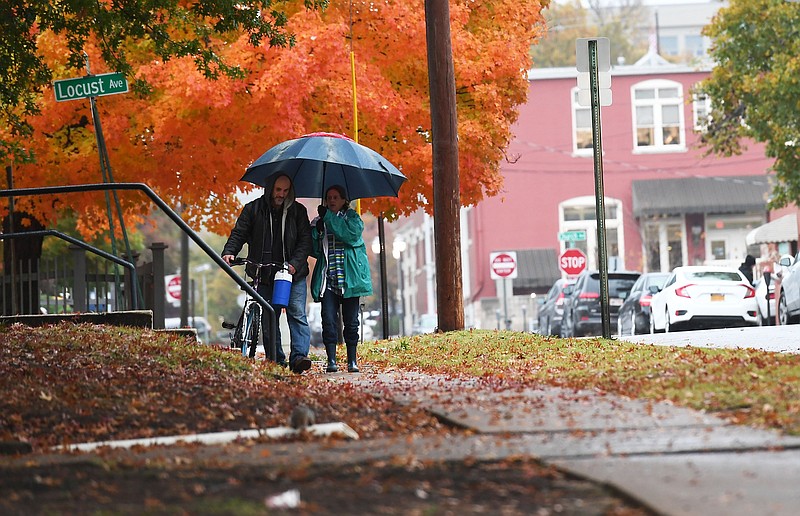 NWA Democrat-Gazette/J.T. WAMPLER Dawn Nelson (right) and Richard Dacheff ((CQ)), both of Fayetteville, walk Wednesday Oct. 30, 2019 along Center St. in Fayetteville during a morning rain. 
The National Weather Service is calling for clear skies and overnight temperatures below freezing in the next few days.