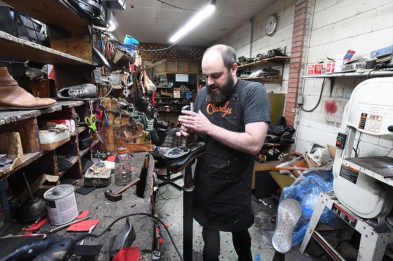 Steven Clardy pulls the sole off of a shoe Thursday at Clardy's Cobbler Shoppe in Fayetteville. The shop has been in business since Clardy’s father bought an existing cobbler shop in 1983. Much of the original equipment is still in use at the shop, some of which date back to the 1950s.
(NWA Democrat-Gazette/J.T.WAMPLER)