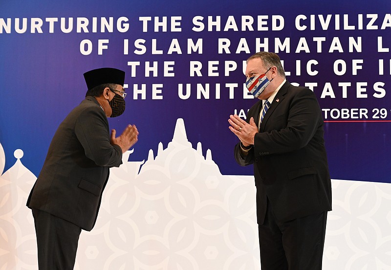 U.S. Secretary of State Mike Pompeo, right, greets General Secretary of Nahdlatul Ulama Yahya Cholil Staquf at the Nahdlatul Ulama in Jakarta Thursday, Oct. 29, 2020. Pompeo renewed the Trump administration’s rhetorical onslaught against China in Indonesia on Thursday as the American presidential election looms. (Adek Berry/Pool Photo via AP)