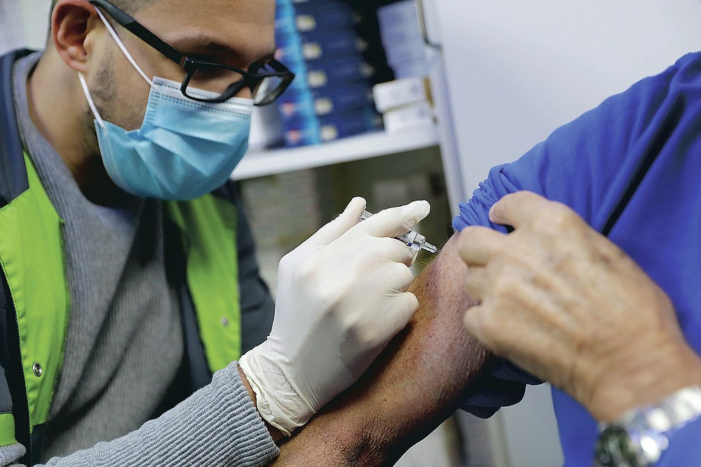 FILE - In this Wednesday, Oct. 14, 2020, file photo, a pharmacist administers a flu shot in a drugstore in Paris. On Friday, Oct. 30, 2020, The Associated Press reported on stories circulating online incorrectly asserting that new data shows flu cases are down 98% around the globe. Social media posts making this claim are providing incomplete information, relying solely on data from countries in the Southern Hemisphere like New Zealand and Australia. The Northern Hemisphere has yet to experience its full flu season. (AP Photo/Lewis Joly)