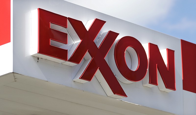FILE- This April 25, 2017, file photo, shows an Exxon service station sign in Nashville, Tenn.  Exxon Mobil reported on Friday, Oct. 30, 2020, lost $680 million in the third quarter as the global pandemic curtailed travel throughout the world, diminishing the need for fuel. Revenue tumbled to $46.2 billion, down from $65.05 billion during the same quarter last year.(AP Photo/Mark Humphrey, File)