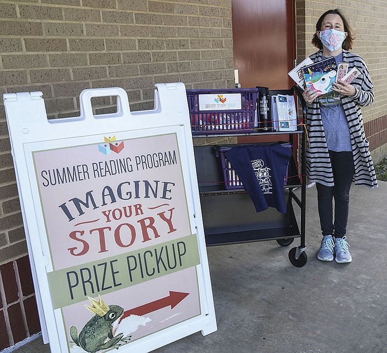 Kasey McKinney, recently retired assistant children’s librarian at the Garland County Library, holds up prizes given out for the summer reading program on Wednesday, June 10. - Photo by Grace Brown of The Sentinel-Record