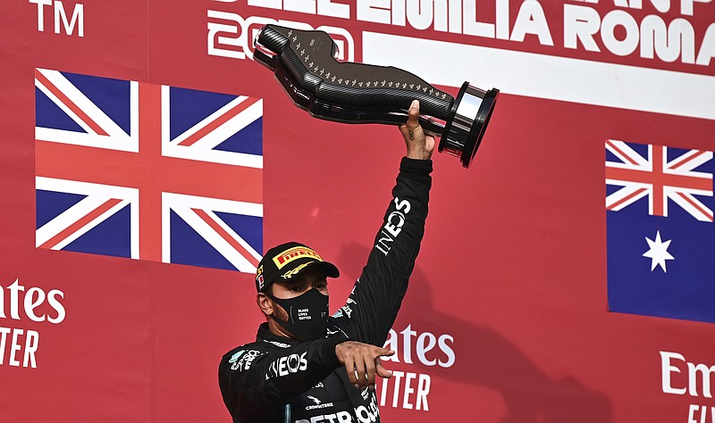 Mercedes driver Lewis Hamilton of Britain holds up the trophy on the podium after winning the Emilia Romagna Formula One Grand Prix, at the Enzo and Dino Ferrari racetrack, in Imola, Italy, Sunday, Nov.1, 2020. (Miguel Medina, Pool via AP)