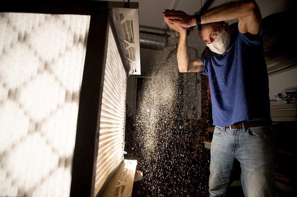 Tom Avril uses sawdust to demonstrates how the air filtering system works. (TNS/Charles Fox/The Philadelphia Inquirer)