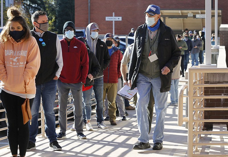 Jim Green (right), a Washington County Election Official, walks the line of voters outside of the Washington County Courthouse in Fayetteville Monday, November 2, 2020, to answer questions  on the last day of early voting. Today is the general election. Check out nwaonline.com/201103Daily/ and nwadg.com/photos for a photo gallery.(NWA Democrat-Gazette/David Gottschalk)