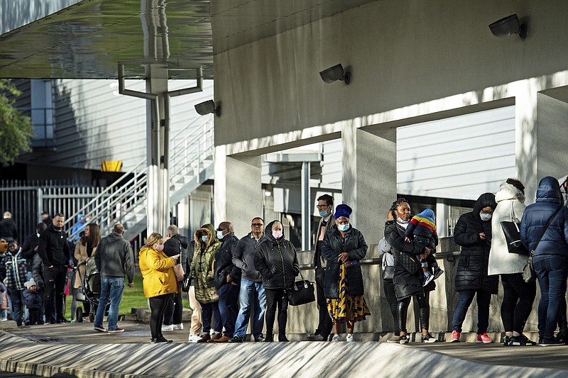Shoppers queue outside a Costco store, ahead of a second lockdown, in Birmingham, England, Monday, Nov. 2 2020. Prime Minister Boris Johnson is facing opposition from his own party as he prepares to ask British lawmakers to back plans for a second national lockdown to combat the exponential spread of COVID-19. Johnson will on Monday provide the House of Commons with details of a proposed four-week lockdown scheduled to begin Thursday. (Jacob King/PA via AP)