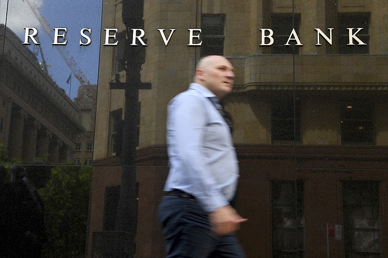 A man walks past the Reserve Bank of Australia headquarters in Sydney, Tuesday, Nov. 3, 2020. Australia’s central bank on Tuesday cut its benchmark interest rate by 0.15 of a percentage point to a record low 0.10% in a bid to lift the economy from a pandemic-induced recession.(Dan Himbrechts/AAP Image)