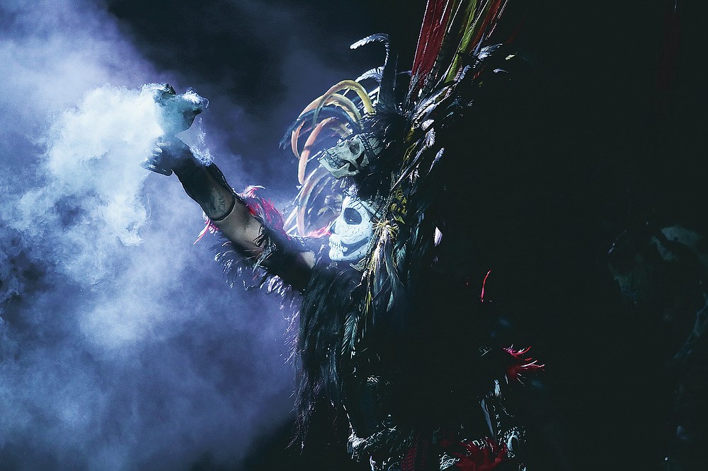 Dancers dressed in traditional costumes perform during an Aztec ceremony to honor of the thousands of residents from the Iztapalapa district who have died from complications related to COVID-19 in Mexico City, Friday, Oct. 30, 2010. Mexico's Day of the Dead celebration this weekend won't be the same in a year so marked by death, in a country where more than 90,000 people have died of the new coronavirus. (AP Photo/Eduardo Verdugo)