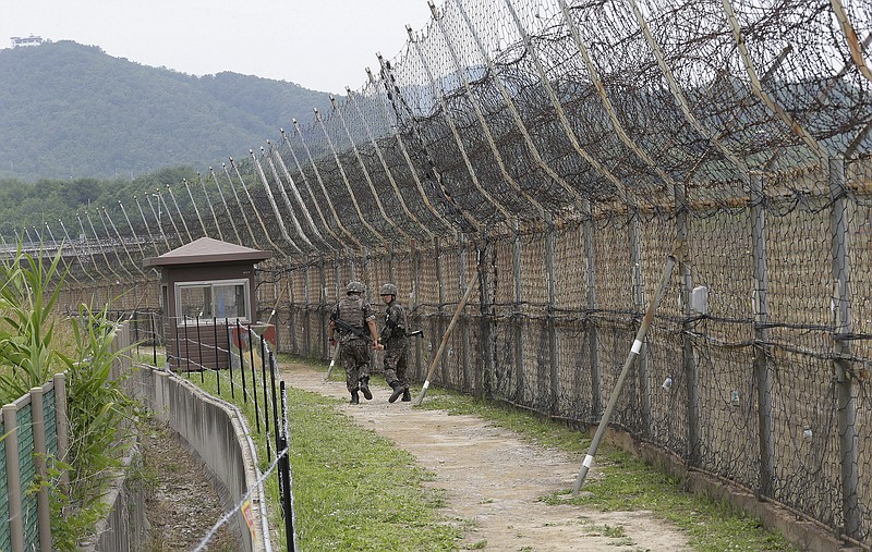 FILE - In this June 14, 2019, file photo, South Korean army soldiers patrol while hikers visit the DMZ Peace Trail in the demilitarized zone in Goseong, South Korea. South Korean troops were engaged in an operation near the heavily fortified border with North Korea on Wednesday, Nov. 4, 2020, after detecting "unidentified personnel" there, the South's military said. (AP Photo/Ahn Young-joon, File) story.lead_photo.caption