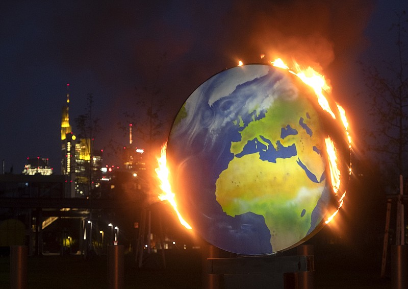 A makeshift globe burns in front of the European Central Bank in Frankfurt, Germany, Wednesday, Oct. 21, 2020. Activists of the so-called "KoalaKollektiv", an organization asking for climate justice, protested with the burning of the globe against the ECB's climate policy. (AP Photo/Michael Probst) story.lead_photo.caption