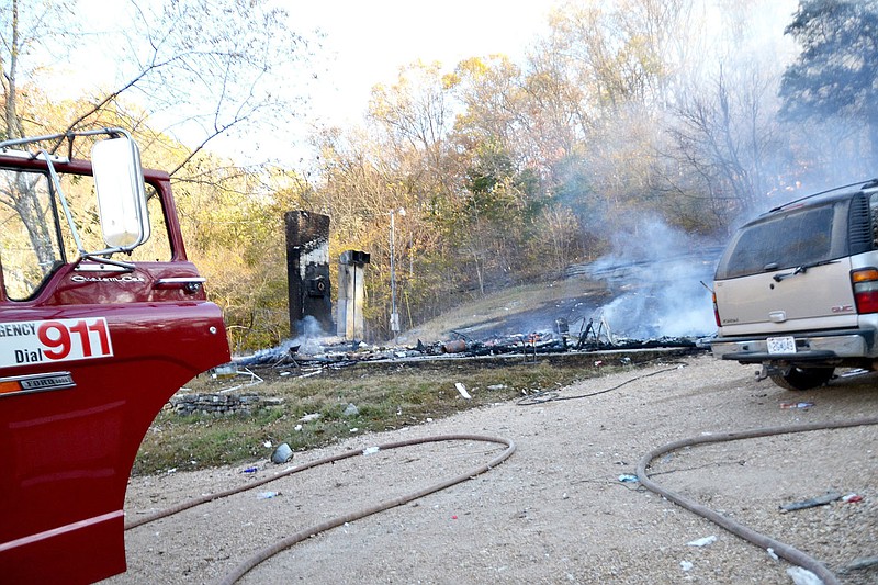 Smoke and flames were still visible about 8 a.m. Wednesdsay at 1600 Buzzard Roost in rural Washburn, Mo., just a few miles north of Pea Ridge. Washburn Fire Chief Danny Dalton and Grant Wheeler, Missouri fire marshal investigator, were at the scene of the structure fire early Wednesday morning to determine the cause of the fire that resulted in injuries to five people. (TIMES photographs by Annette Beard)