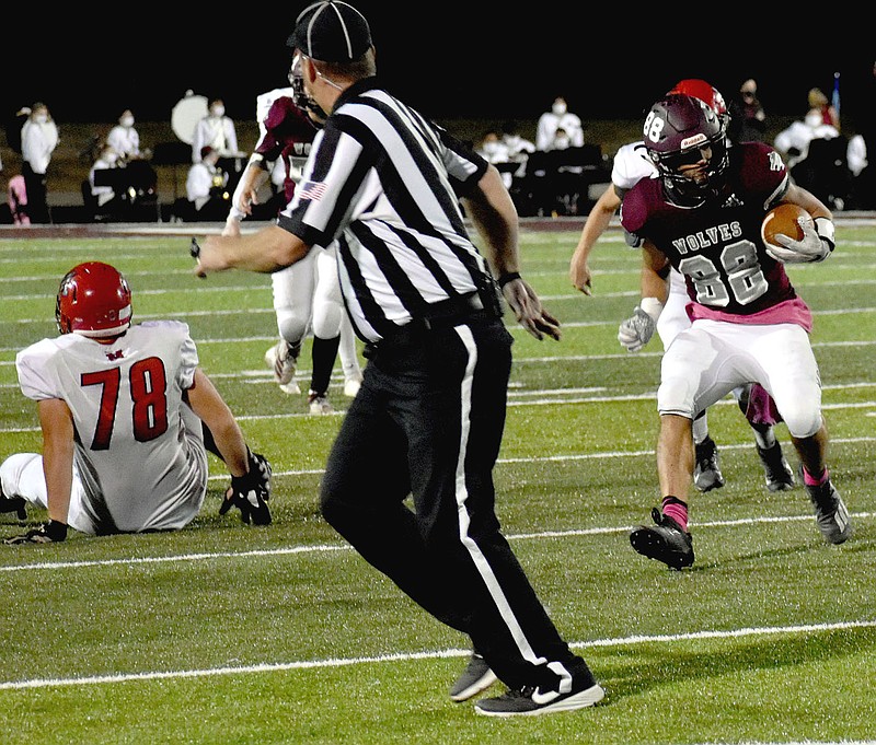 MARK HUMPHREY  ENTERPRISE-LEADER/A referee scramble to get out of the path as Lincoln senior Daytin Davis runs the ball cutting between defenders. Davis rushed 10 times for 64 yards including a 32-yard touchdown carry and caught 3 passes for 27 yards in the Wolves' 37-14 playoff win at Atkins Friday.