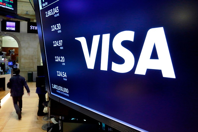 FILE- In this April 23, 2018, file photo, the logo for Visa appears above a trading post on the floor of the New York Stock Exchange.  The Department of Justice sued payment processing giant Visa Inc. on Thursday, Nov. 5, 2020,  to block the company’s purchase of financial technology startup Plaid, calling it a monopolistic takeover of a potential competitor to Visa’s ubiquitous payments network.  (AP Photo/Richard Drew, File)