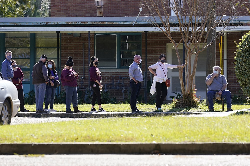 Voters take advantage of an awning to provide them shade while they wait to cast their ballot at Precinct 45 in Jackson, Miss., Tuesday, Nov. 3, 2020. (AP Photo/Rogelio V. Solis)