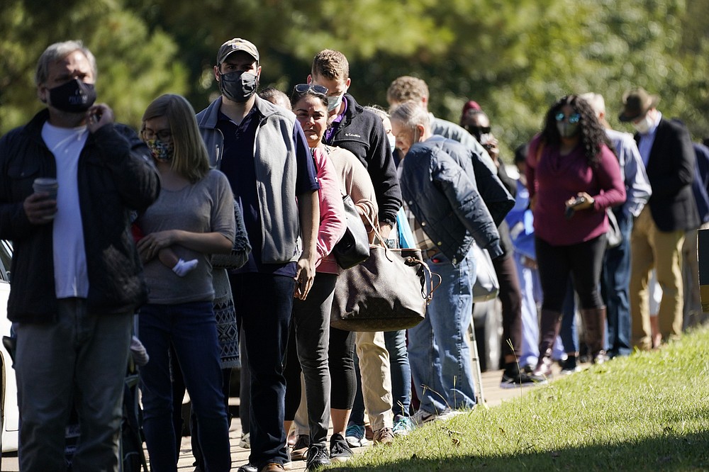 Voters brave a bright sun as they wait to cast their ballots at Precinct 45 in Jackson, Miss., Tuesday, Nov. 3, 2020. Some voters complained of slow moving lines after waiting for a couple of hours before casting their ballot. (AP Photo/Rogelio V. Solis)