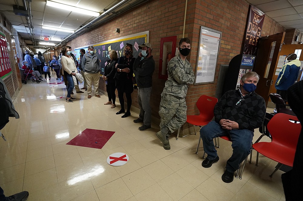 After standing outdoors in line for a couple of hours as they waited their turn to vote, these voters finally made it indoors to the entrance of Precinct 45 where they would cast their votes on Election Day in Jackson, Miss., Tuesday, Nov. 3, 2020. (AP Photo/Rogelio V. Solis)