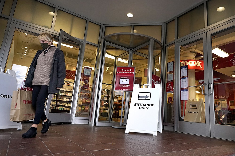 FILE - In this Oct. 27, 2020, file photo, a shopper steps out of a department store in Boston. Defying fears of another slowdown, U.S. businesses kept hiring at a solid pace in October yet there are signs they remain cautious about the economy's future as the pandemic worsens. (AP Photo/Steven Senne, File)
