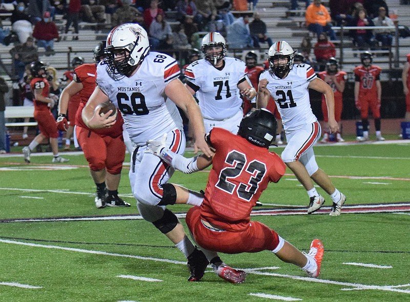 RICK PECK/SPECIAL TO MCDONALD COUNTY PRESS McDonald County defensive lineman Garreett GrickS (68) gets tripped up by West Plains' Heston Miller (23) after intercepting a deflected pass during the Zizzers' 35-2 win on Nov. 6 in the Missouri Class 4 District 5 semifinals at West Plains High School.