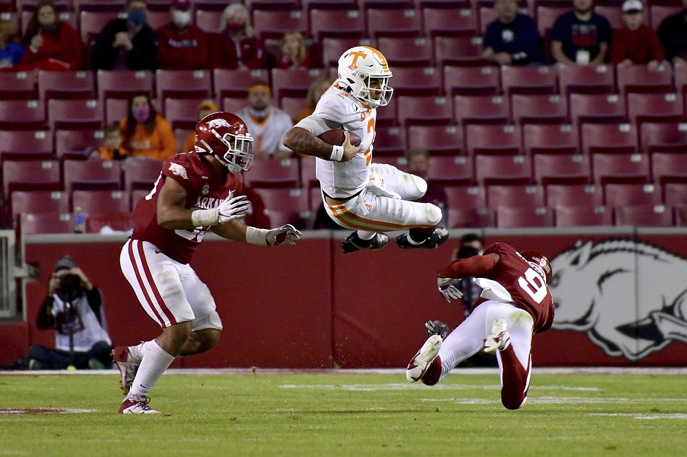 Tennessee quarterback Jarrett Guarantano (2) is tackled by Arkansas defenders Isaiah Nichols, left, and Greg Brooks Jr. during the second half of an NCAA college football game Saturday, Nov. 7, 2020, in Fayetteville, Ark. (AP Photo/Michael Woods)