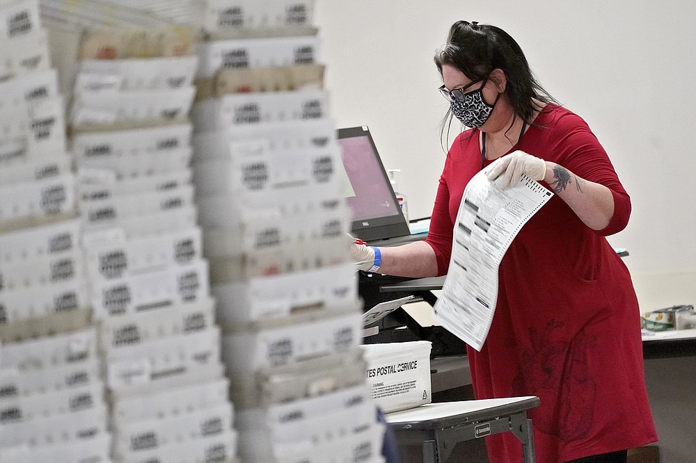 In this Nov. 6, 2020, photo, Arizona elections officials continue to count ballots inside the Maricopa County Recorder's Office in Phoenix. The 2020 presidential election officially entered the record books Saturday the turnout reached 61.8%, eclipsing the recent mark set by Barack Obama's first presidential campaign in 2008 and demonstrating the extraordinary engagement of Americans in the referendum on Donald Trump's presidency. (AP Photo/Matt York)