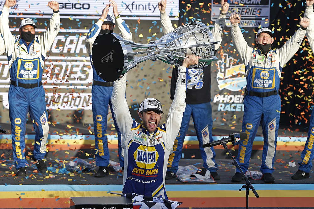 Chase Elliott holds up the season championship trophy as he celebrates with his race crew in Victory Lane after winning a NASCAR Cup Series auto race at Phoenix Raceway, Sunday, Nov. 8, 2020, in Avondale, Ariz. (AP Photo/Ralph Freso)