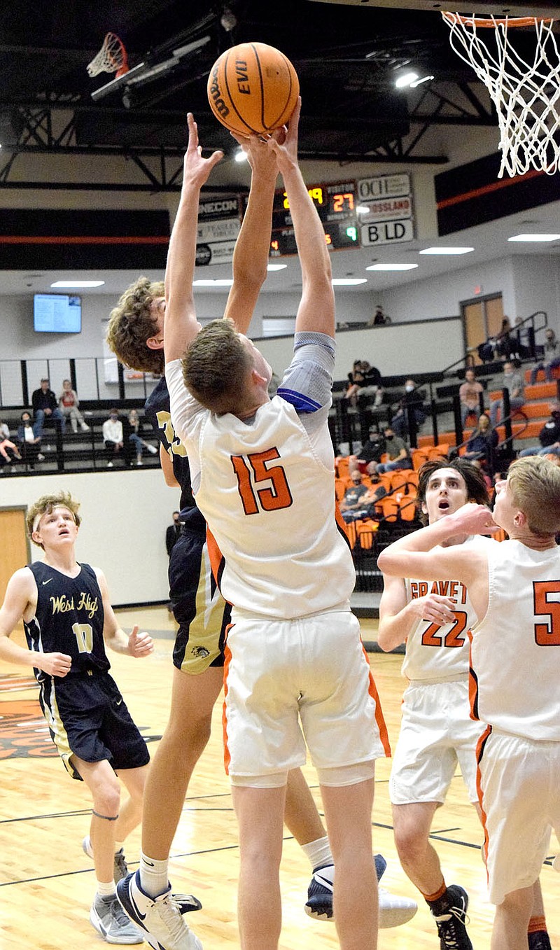 Westside Eagle Oberserver/MIKE ECKELS

Lion Tristen Batie (15) and Wolverine Tucker Anderson (in front) fight over a rebound during the closing minute of the first half of the Gravette-Bentonville West varsity basketball contest in the new gym at Gravette High School Nov. 12. Anderson managed to tip the ball away but it landed in the arms of a Lion player.