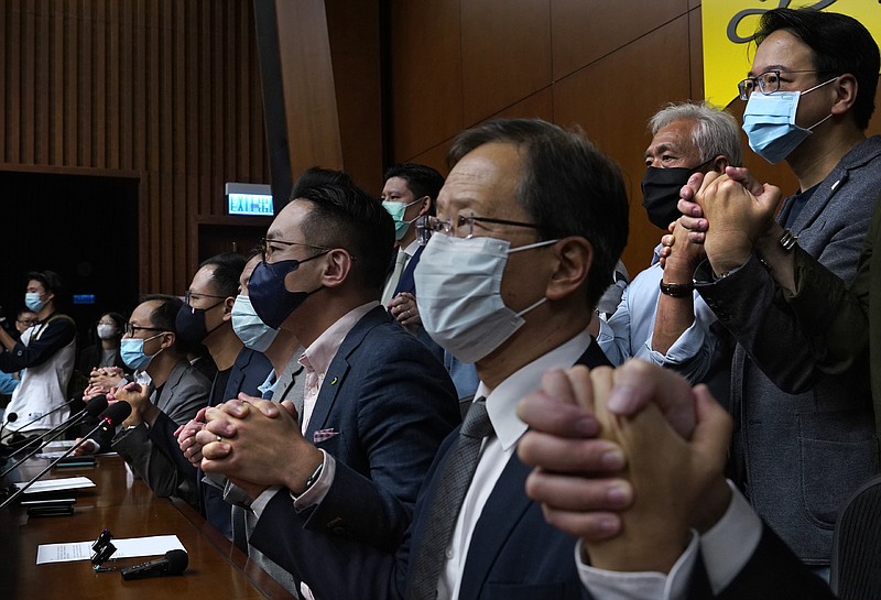 Hong Kong's pro-democracy legislators holding hands pose a picture during a press conference at the Legislative Council in Hong Kong, Monday, Nov. 9, 2020. The lawmakers said Monday that they would resign en masse if Beijing disqualifies any of them. The announcement came amid unconfirmed reports that Beijing would oust four legislators for filibustering meetings and violating their oath. (AP Photo/Vincent Yu)