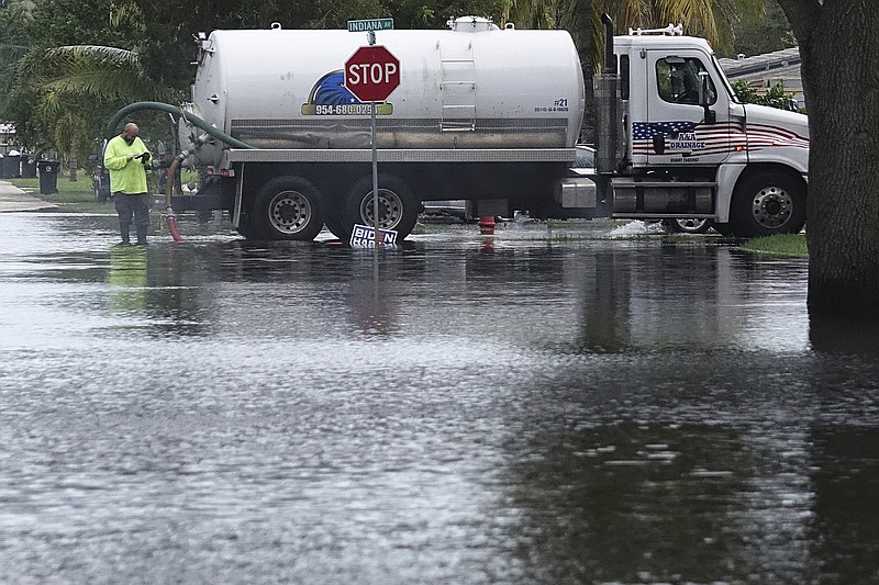 A vacuum truck sucks water in the Melrose Park neighborhood of Fort Lauderdale, Fla., Tuesday, Nov. 10, 2020. Tropical Storm Eta is squatting off western Cuba, and forecasters say it's unclear where it might strike land again. It dumped torrential rain on Cuba and South Florida, flooding entire neighborhoods. (Joe Cavaretta/South Florida Sun-Sentinel via AP) story.lead_photo.caption