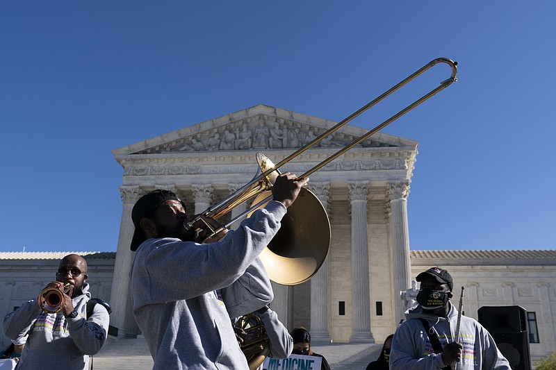 The "Too Much Talent," band performs in front of the U.S. Supreme Court as arguments are heard about the Affordable Care Act, Tuesday, Nov. 10, 2020, in Washington. (AP Photo/Alex Brandon)