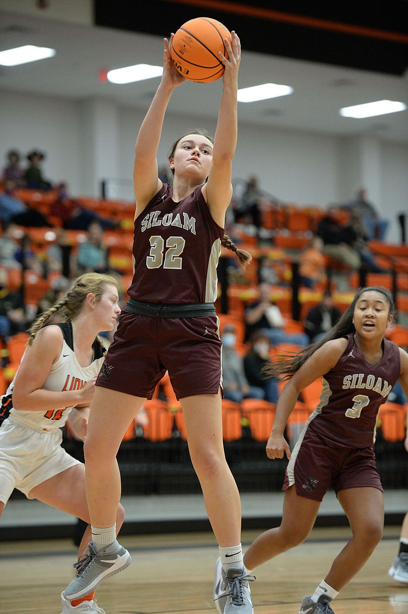 Siloam Springs' Brooke Ross (32) pulls down a rebound Tuesday during the first half of play against Gravette. The Lady Panthers defeated the Lady Lions 71-59 in both teams' season-opener.