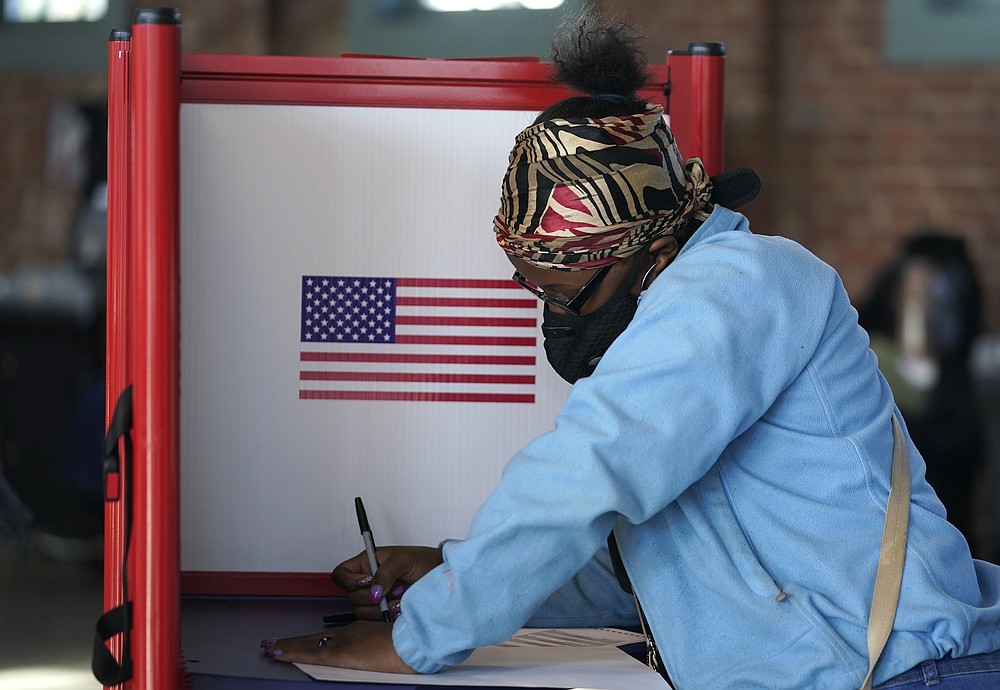 FILE - In this Tuesday, Nov. 3, 2020, file photo, Johnea Barlow casts her ballot at the Kentucky Center for African American Heritage, on Election Day in Louisville, Ky. The 2020 presidential election had all the makings of a looming disaster: fears of Russian meddling, violence at the polls, voter intimidation and poll workers fleeing their posts over the coronavirus. But the election was largely smooth, in large part because 107 million voters that cast their ballots early and took the pressure off Election Day operations. (AP Photo/Darron Cummings, File)