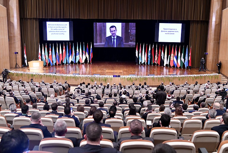 CORRECTS DATE TO NOV. 11, 2020 -- This photo released by the Syrian official news agency SANA, shows Syrian President Bashar Assad virtually addressing the opening session of a two-day international conference on the return of refugees to Syria, organized by Russia, in Damascus, Syria, Wednesday, Nov. 11, 2020. The Syrian government is working to secure the return of millions of refugees who fled war in their country, but Western sanctions are hindering the work of state institutions, complicating those plans, Assad said Wednesday. (SANA via AP) story.lead_photo.caption