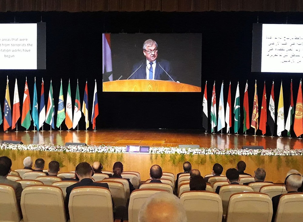 In this photo released by the Syrian official news agency SANA, the Russian President's Special Envoy for Syria Alexander Lavrentiev virtually addresses the opening session of a two-day international conference organized by Russia on the return of refugees, in Damascus, Syria, Wednesday, Nov. 11, 2020. The Syrian government is working to secure the return of millions of refugees who fled war in their country, but Western sanctions are hindering the work of state institutions, complicating those plans, President Bashar Assad said Wednesday. (SANA via AP)